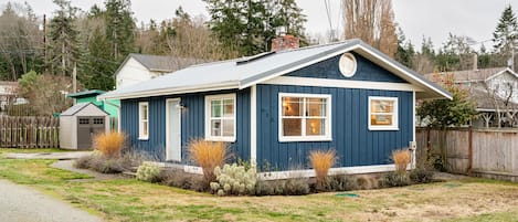 Front of house showing living room and kitchen windows facing the water