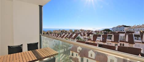 Sunny balcony with outdoor dining area for four guests