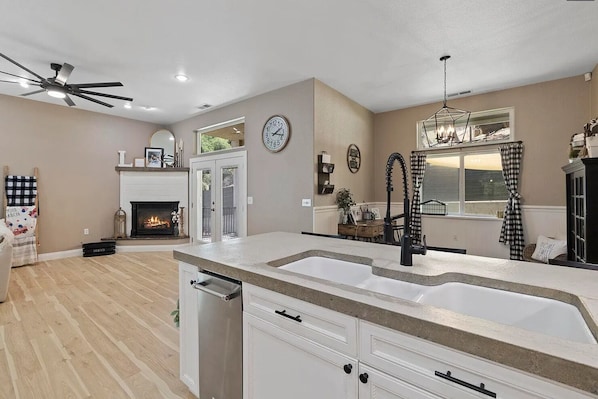 Living room has a cozy fire log fireplace and a French door leads to the patio.