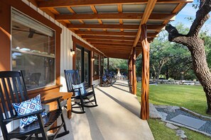 The porch wraps around on the guest house and covers an outdoor game area.