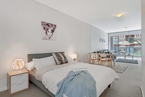 A bedroom area with a queen sized bed & plush pillows.