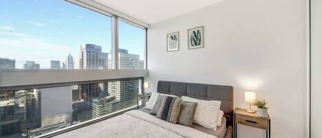 The master bedroom with a queen-sized bed and plush pillows.