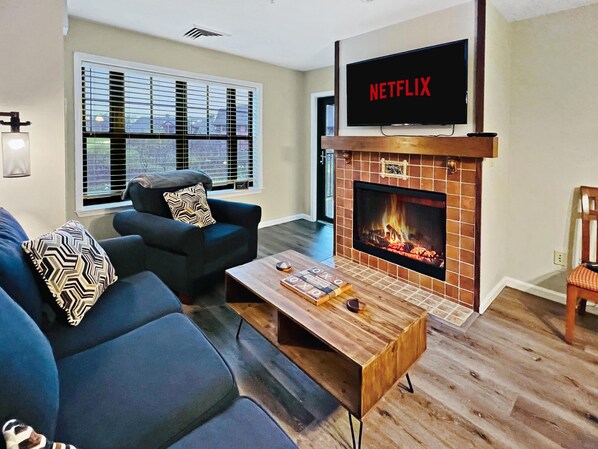 Comfy living area complete with a gas fire place, smart TV and a sofa bed.