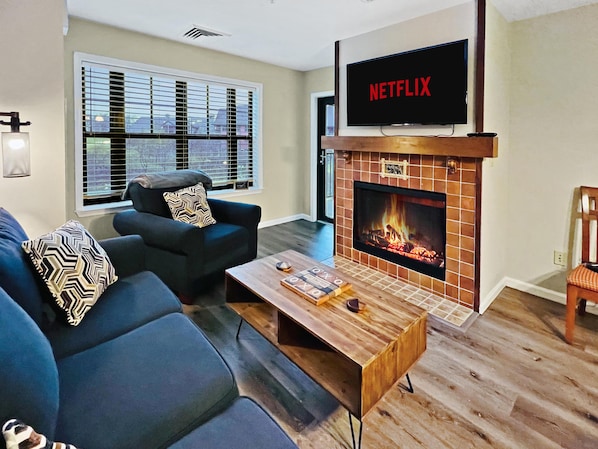 Comfy living area complete with a gas fire place, smart TV and a sofa bed.