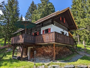 Die Sechszirbenhütte im Sommer – mit Sonnenschirm auf dem Balkon.