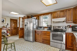 Kitchen area well stocked and a door to the washer and dryer