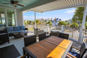 This covered balcony off of the dining room and living room has ocean views & salty sea breezes.