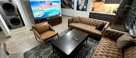 Lounge room with 85" high resolution Sony digital TV and open plan kitchen