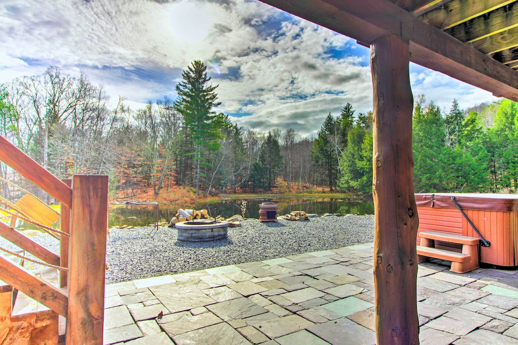 Patio with hot tub, fire pit, and scenic views at one of the best cabins for couples in Vermont