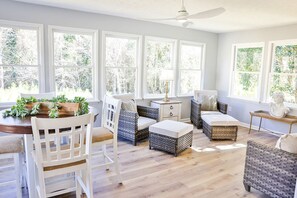 Gorgeous sunroom with a breakfast set and  lots of extra seating