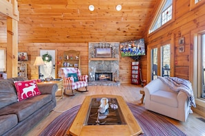 Living Room with Stone Gas Log Fireplace and Mounted Big Screen TV