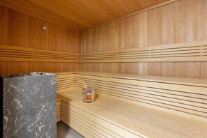 A cozy wooden sauna room with a bench and heater, offering a relaxing spa experience.