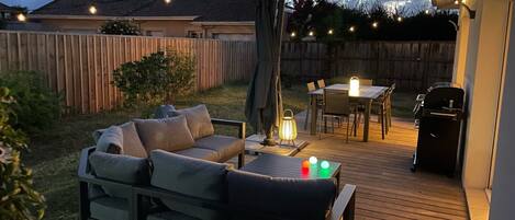 Vue Terrasse équipée d'un salon, d'une table de jardin, et d'un parasol