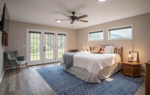 Master bedroom with king bed and screen doors to outside patio and river below 