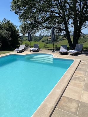 South facing large heated sole use pool with loungers umbrellas and beach towels