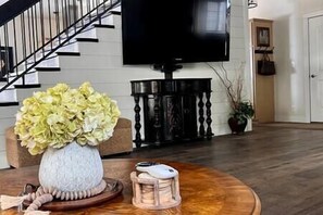 Large TV can be viewed from both the living room and game table area.