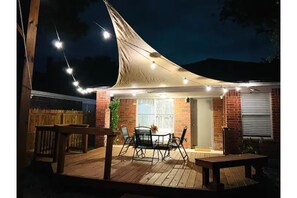 Back yard wood deck lights up at night.
