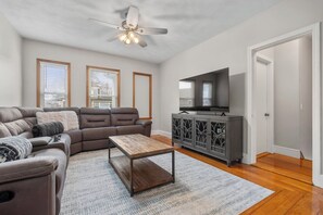 Living room with 65" Smart TV and wrap-around sectional for 6