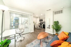 Tastefully decorated living room with dedicated workspace and an unfolding sofa.