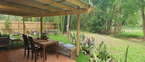  undercover outdoor dinning and sitting area viewing the garden and the creek 