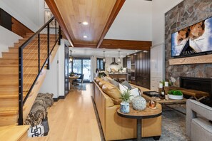 Living Room with leather sectional/sofa sleeper, arm chairs, gas fireplace, and 75" Smart TV