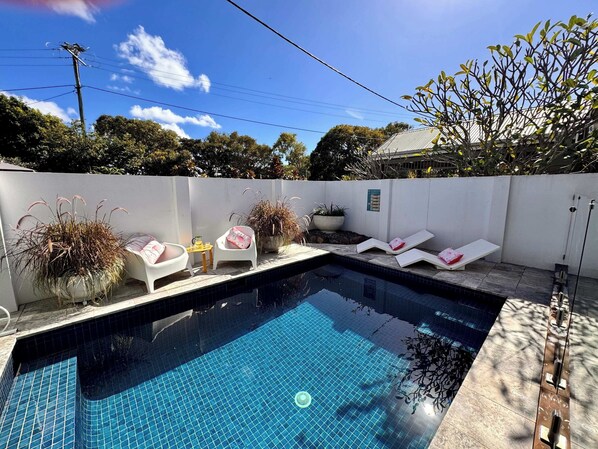 Privately fenced heated pool in front of house