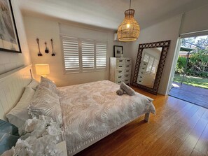 Doors in main bedroom open out onto back deck overlooking garden