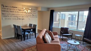 Stylish Living Room and Dining Area featuring Custom Murals, Smart TV, Shuffleboard, Bar Cart and Record Player