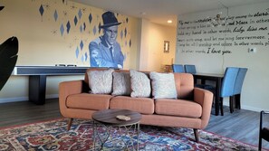 Stylish Living Room and Dining Area featuring Custom Murals, Smart TV, Shuffleboard, Bar Cart and Record Player