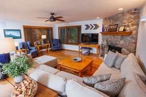 The main living area includes plenty of seating and a gorgeous stone, wood burning fireplace