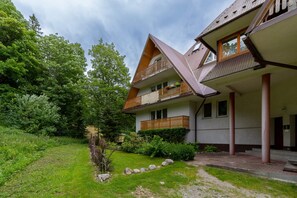 A view of the charming property surrounded by lush greenery, featuring a traditional architecture style.