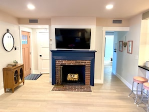 Original wood-burning fireplace and smart TV.