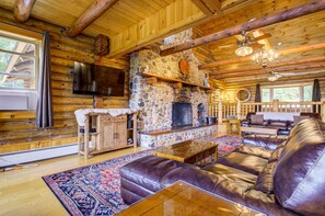 Enjoy the warmth of the fireplace and the luxurious feel of leather couches in our well-lit living room, complete with an entertainment setup.