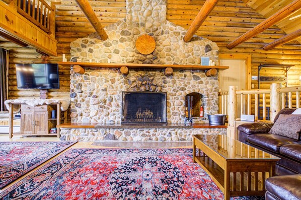Cozy up by the fireplace in our living room, adorned with a rich brown leather sofa for ultimate comfort.