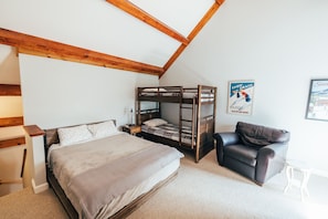 Large upstairs loft with a queen bed, two twin beds, Smart tv, lounge chair and full bathroom.