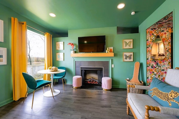 Cozy times by the fireplace in this lovely living room with soothing green walls. 🌿 #HomeVibes
