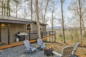 Front view of cabin with fire pit and grill