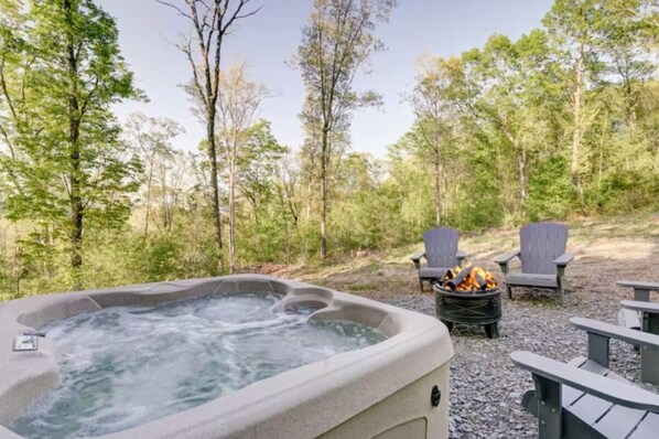 Relaxing hot tub and fire pit for roasting marshmallows, hot dogs, and summertime campfire stories.