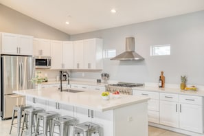 Sleek kitchen is easy to keep stocked with convenient grocery shopping just an 8-minute drive away.