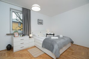 A well-lit bedroom featuring a bed, storage furniture, and modern decor.