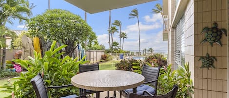 Ground level lanai with a view of the pool and swaying palm tree