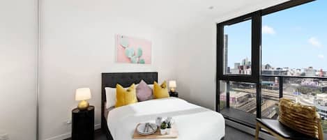 The master bedroom with a double sized bed & city views.