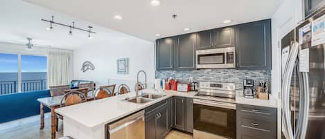 Beautifully updated, fully equipped kitchen featuring quartz countertops and stainless-steel appliances.