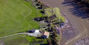 Aerial photo of house, garage, garbage shed, and river access.