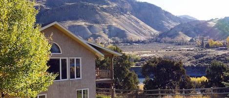 Large fenced yard and covered riverside deck and patio.