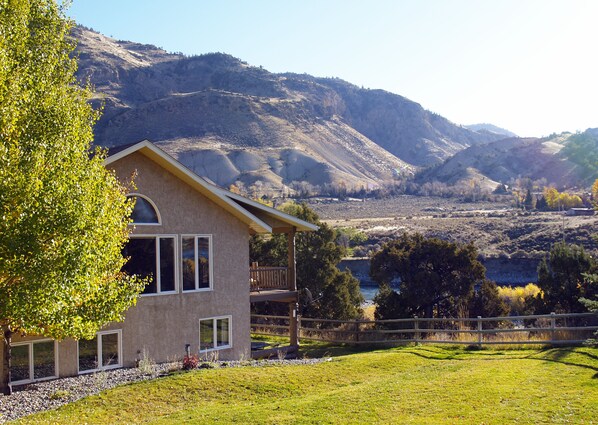 Large fenced yard and covered riverside deck and patio.