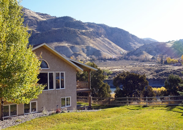 Large fenced yard and covered riverside deck and patio.