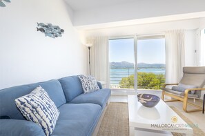 Cozy living room with blue sofa and panoramic bay views in Pollensa.