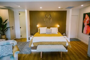 King bed with crisp sheets and designer bedding on a posturepedic mattress