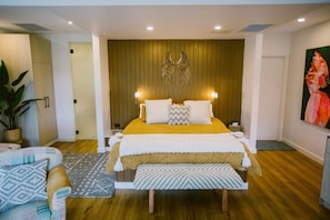 King bed with crisp sheets and designer bedding on a posturepedic mattress